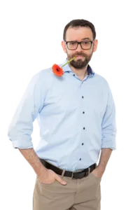 Gerd Beidernikl mit Blume Gerd Beidernikl mit einer organgeroten Gerbera-Blume im Mund und gekräuselten Augenbrauen, die Hände in den Hosentaschen