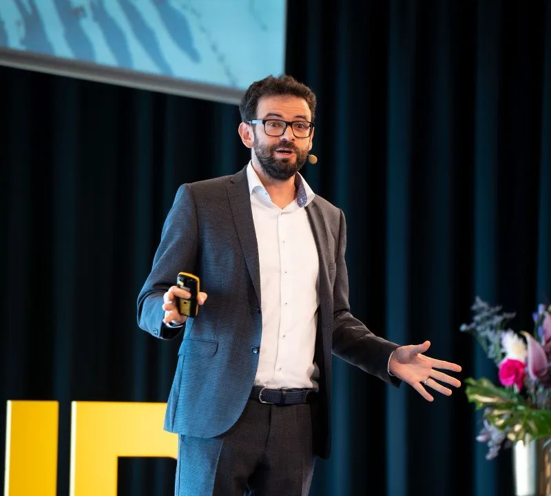 Keynote Speaker Gerd Beidernikl auf der bühne vor dunklem Vorhang.