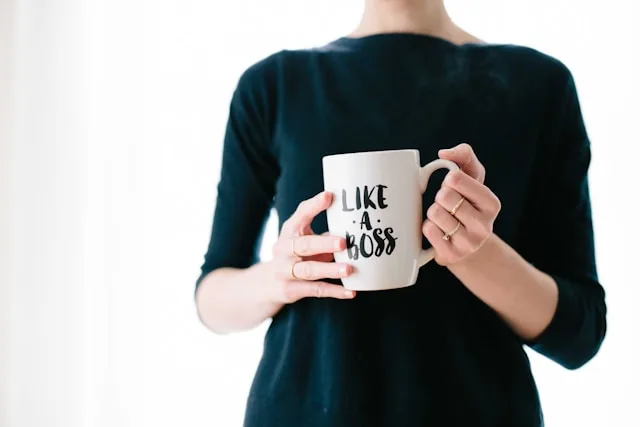 Leadership Experience, eine Person hält eine weiße Tasse. Auf dieser steht der Schriftzug "Like a Boss"