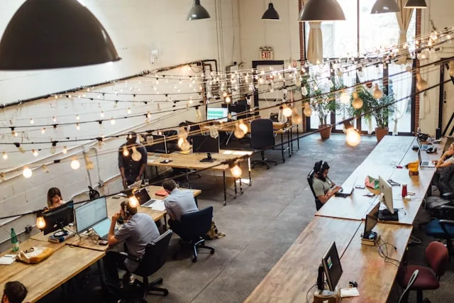 Employee Experience, zu sehen ist ein modernes Co-Working Cafè. An den Tischen arbeiten viele Menschen konzentriert an ihren Laptops.